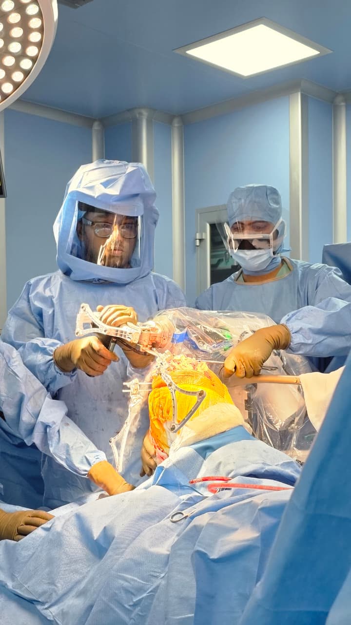 VELYS robotic-assisted knee replacement in progress at DHS Multispecialty Hospital, Ahmedabad — surgeon using tracking array during robotic-guided bone preparation
